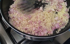 risotto rice, shallots and garlic frying
